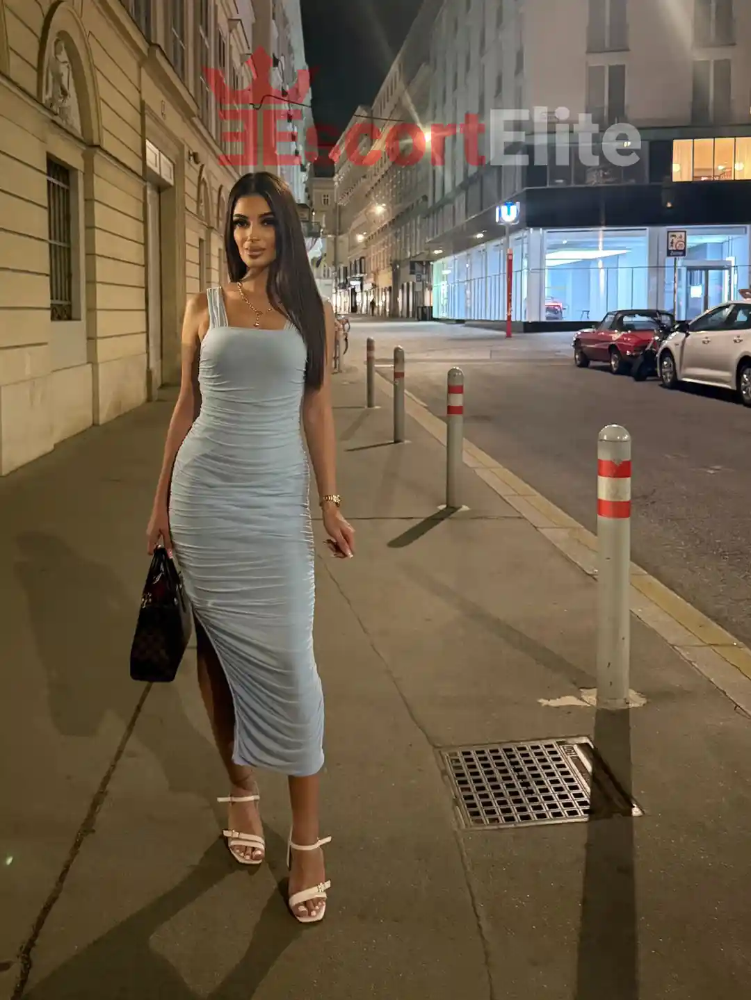 Escort Wien Kassandra im hellblauen Bodycon-Kleid bei einem Abendspaziergang durch Wien